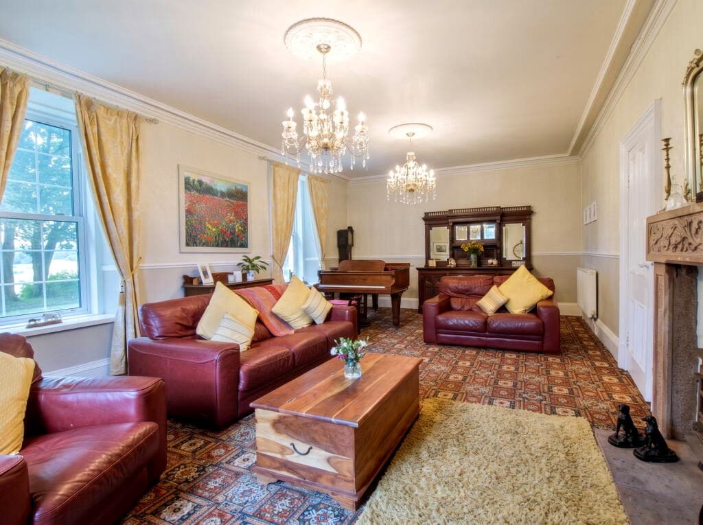 Large dual-aspect drawing room with fireplace and estuary-facing windows